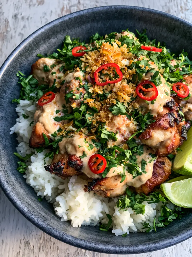 Coconut Chicken Rice Bowl with Charred Chicken and Glossy Sauce 1 Coconut Chicken Rice Bowl garnishes including toasted coconut flakes, red chili, and fresh lime.