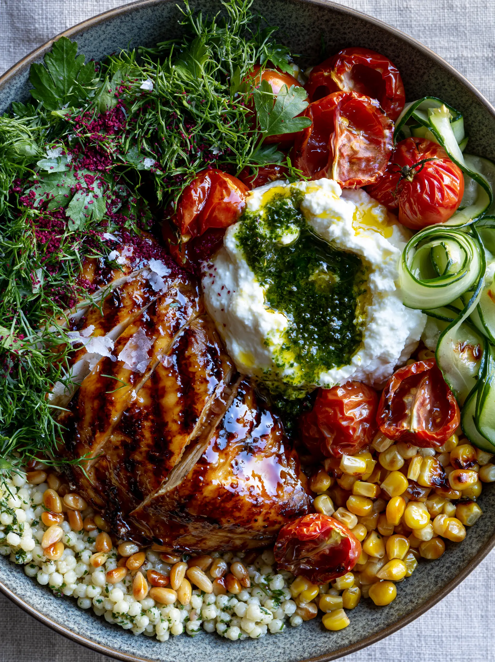 Summer Dinners: The Vibrant Mediterranean Grilled Chicken Harvest Bowl with Whipped Feta 3 Macro shot of glistening honey-lemon chicken with charred grill marks on a bed of pearl couscous. (Summer Dinners)
