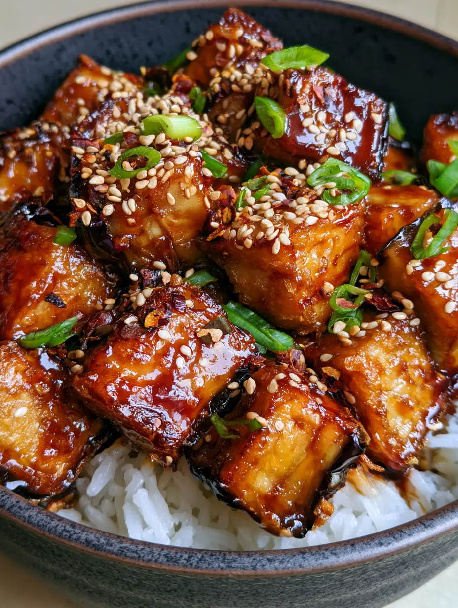 Fried Eggplant with Rice: The Ultimate Crispy Soy-Garlic Bowl 3 Macro shot of Fried Eggplant with Rice showing the thin, crunchy starch coating and glossy garlic glaze over steaming jasmine rice.