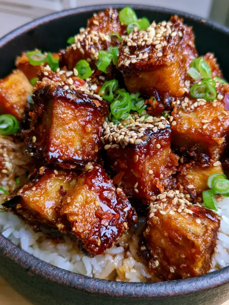 Fried Eggplant with Rice: The Ultimate Crispy Soy-Garlic Bowl 1 A vibrant bowl of Fried Eggplant with Rice in a matte black ceramic bowl garnished with bright green scallions and red chili flakes.