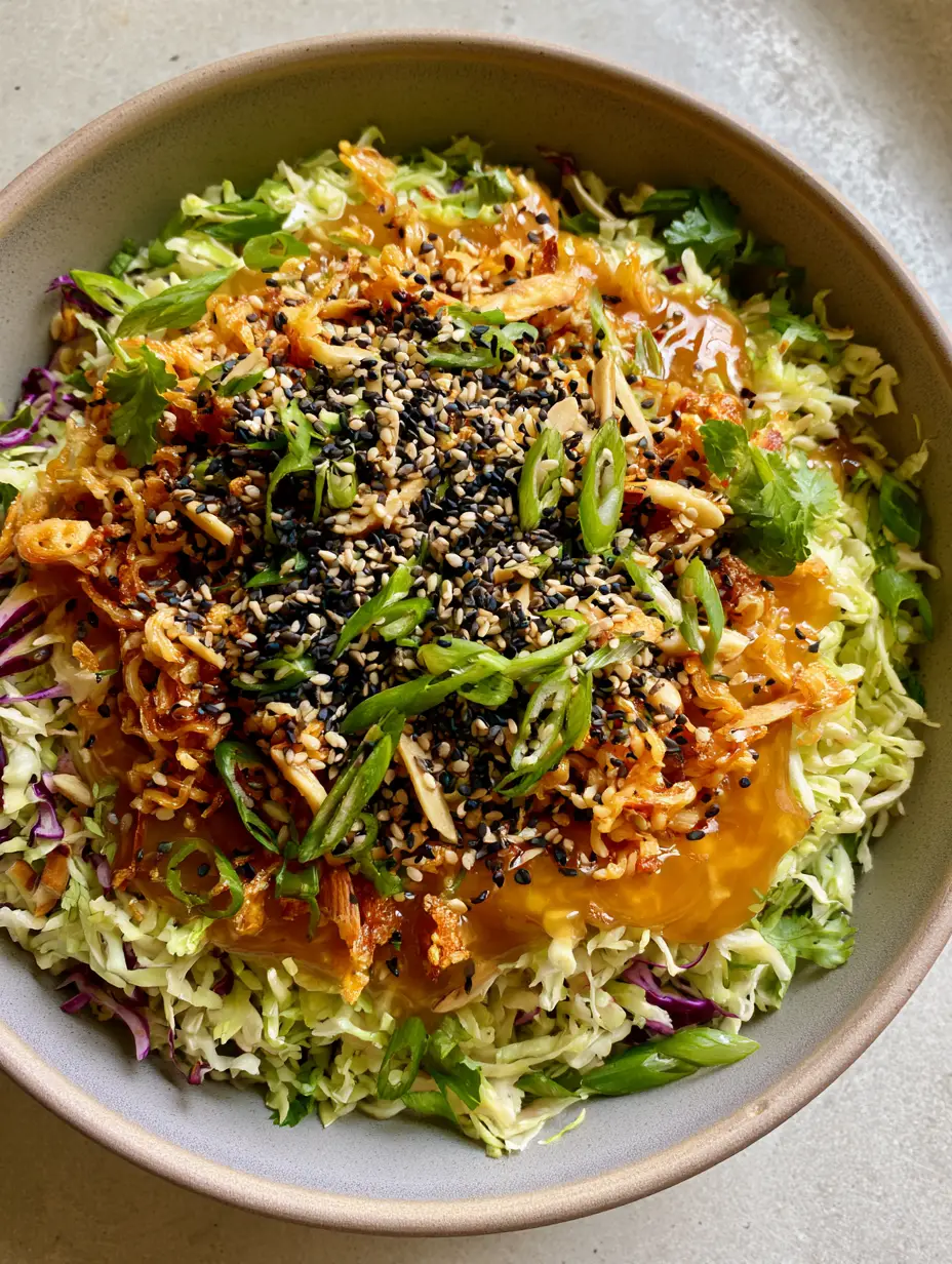 Top-down view of Napa cabbage salad showing the contrast of pale green and deep purple cabbage with golden toasted ramen.