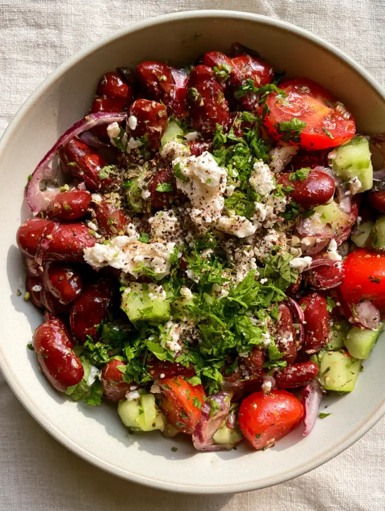 Overhead view of a Mediterranean Kidney Bean Salad garnished with vegan feta and fresh parsley.
