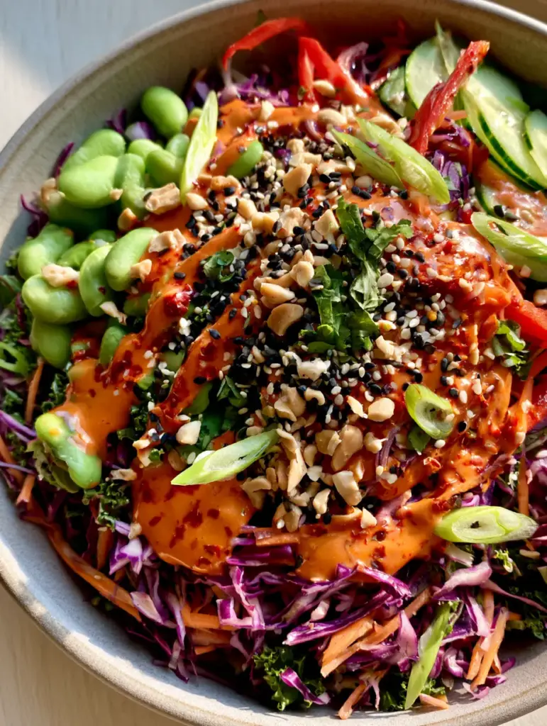 Spicy Asian Salad: The Ultimate Crunchy Chopped Salad with Chili Peanut Dressing 2 Top-down macro shot of Spicy Asian Salad showing shredded cabbage, edamame, and glossy chili oil dressing with red pepper flakes. (Spicy Asian Salad)