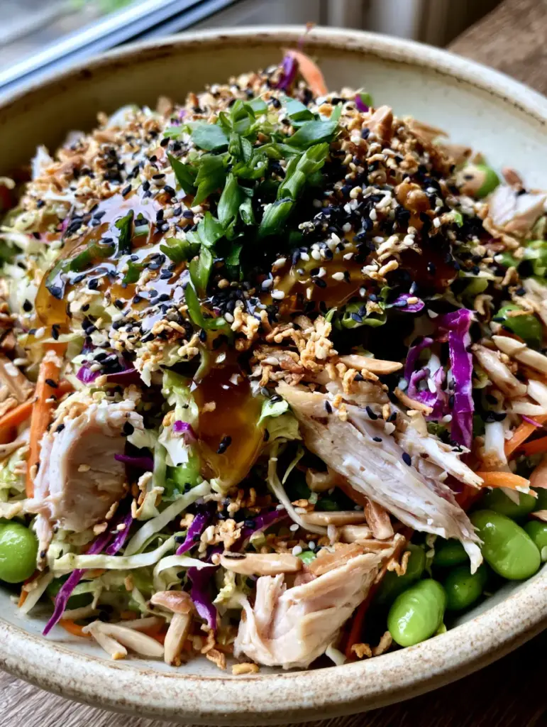 Close up of glossy sesame ginger dressing drizzled over an Asian salad. (Asian salad)