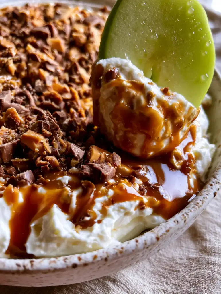 Caramel Apple Dip with Heath Bar Toffee and Chocolate 2 Macro shot of whipped cream cheese with viscous amber caramel sauce and Heath bar bits. (Caramel Apple Dip)