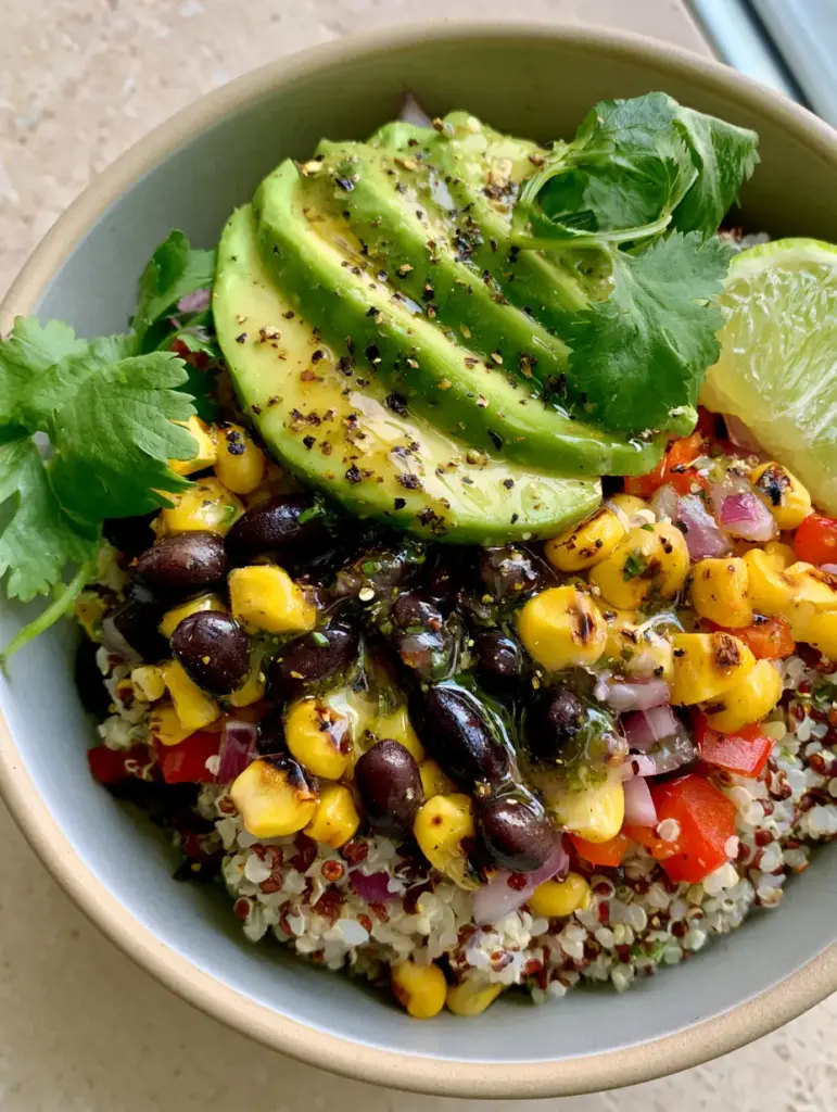Southwest Quinoa Salad with Charred Corn and Cilantro-Lime Vinaigrette 1 Close up of perfect avocado slices fanned over a bed of red and white quinoa and black beans.