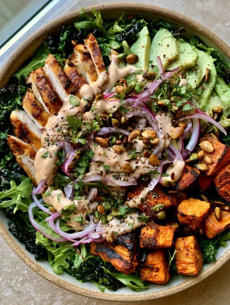 Whole30 Salad Bowl with Seared Chicken and Roasted Sweet Potatoes 1 Close up of caramelized sweet potato cubes and fresh avocado wedges in a Whole30 salad bowl.